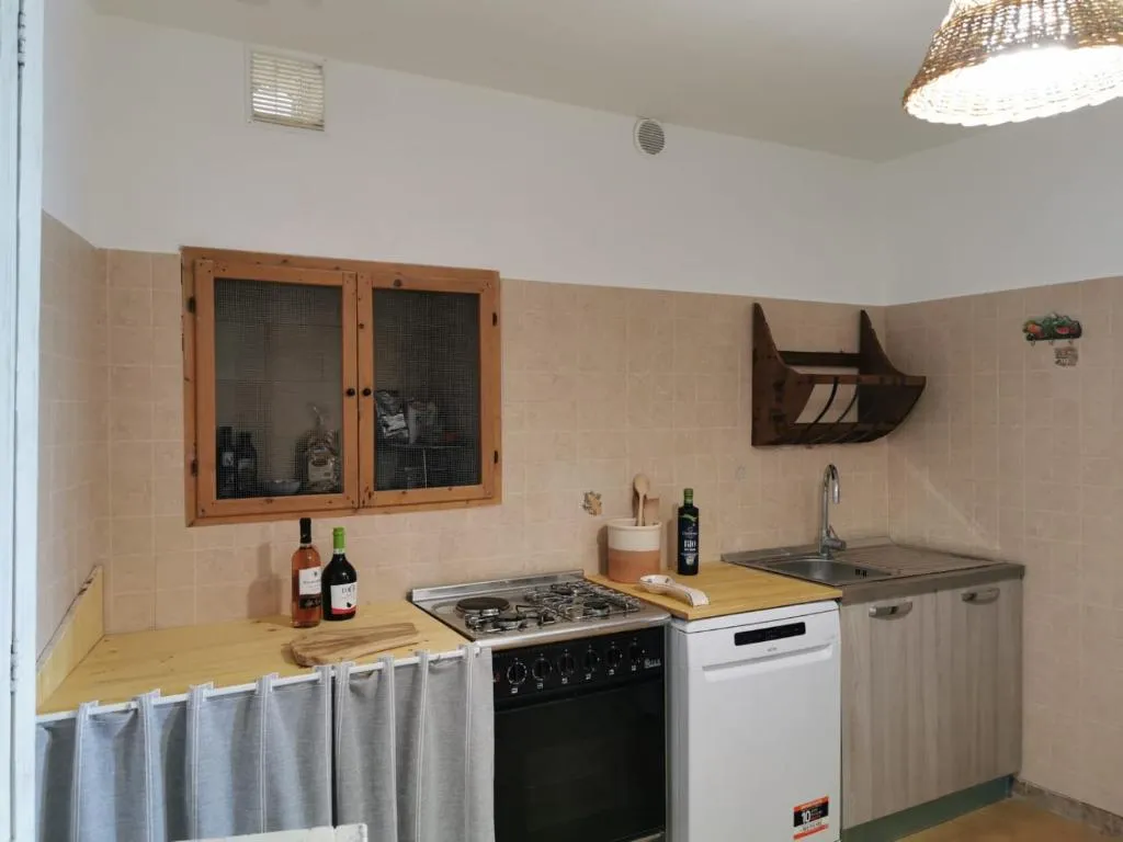 Cucina attrezzata con zona fuochi e lavandino a Villa Mare Blu