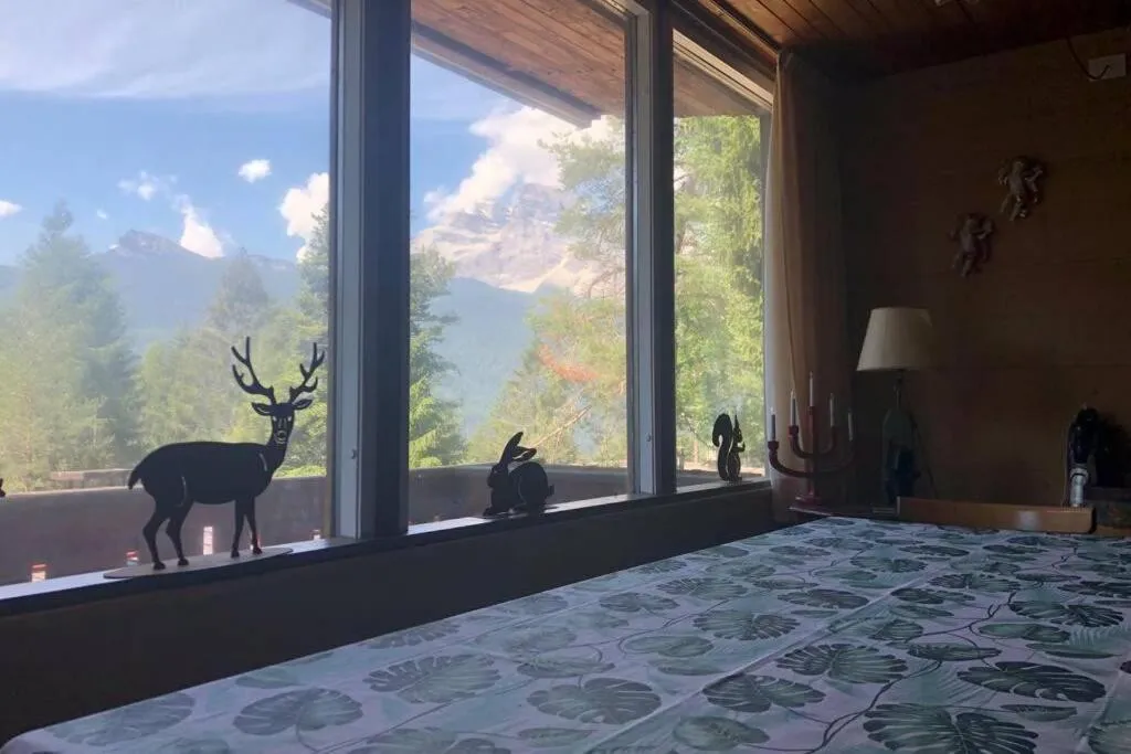 Vista su cime e bosco dal soggiorno di Chalet nel Bosco